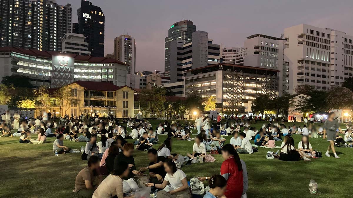 Everyone is free to sit in this lawn. Looks like a picnic at night.